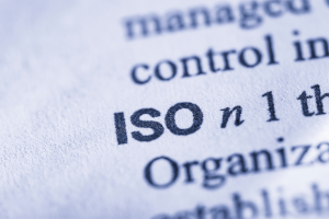Nahaufnahme eines Wörterbuchs mit dem hervorgehobenen Begriff ISO – Symbol für Normen, Standards und Qualitätsmanagement.
